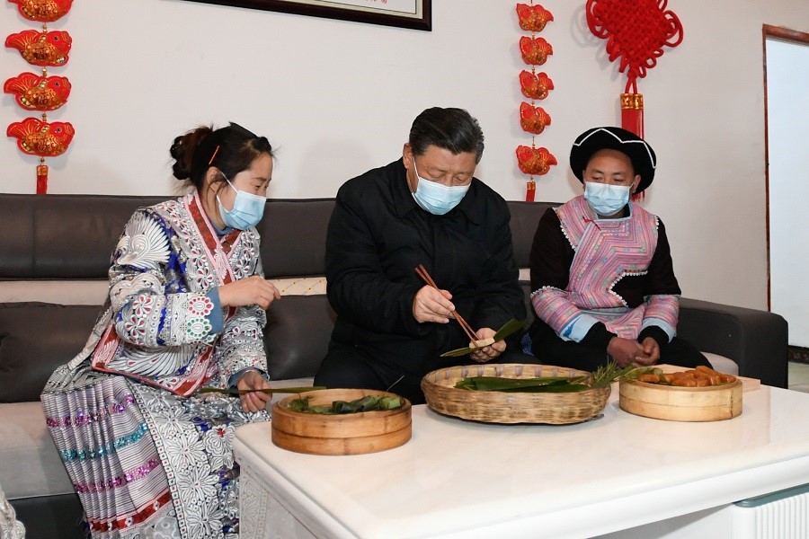 2021年2月3日下午，習近平在貴州畢節(jié)市黔西縣新仁苗族鄉(xiāng)化屋村苗族村民趙玉學家，同一家人邊聊家常邊制作當?shù)貍鹘y(tǒng)節(jié)日食品黃粑。新華社記者 李學仁 攝