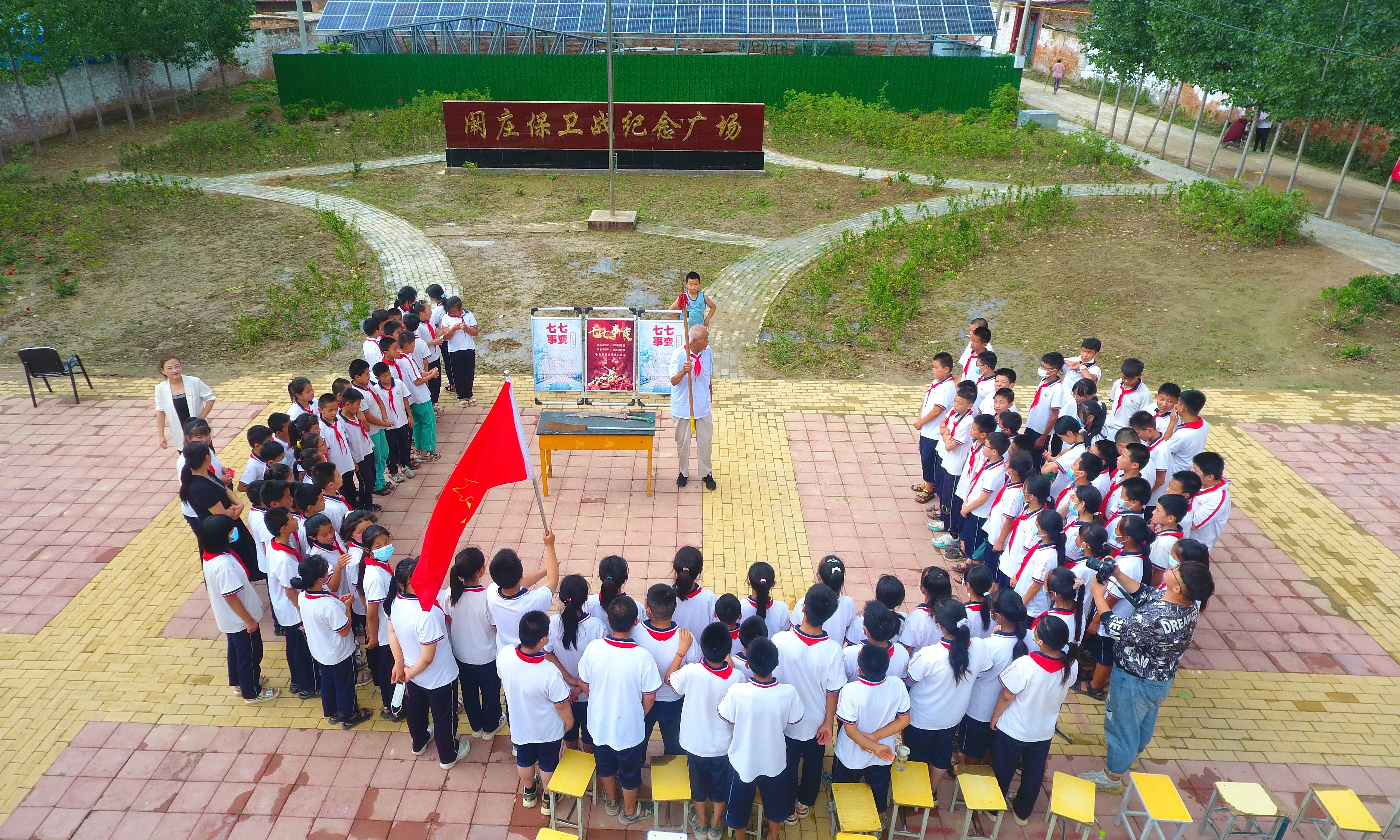 2022年7月6日，山東省聊城市，在茌平區(qū)菜屯鎮(zhèn)闞莊村的闞莊保衛(wèi)戰(zhàn)紀念廣場，闞莊保衛(wèi)戰(zhàn)親歷者王光木老人，為小學生們講述抗戰(zhàn)故事，展示大刀、長矛。