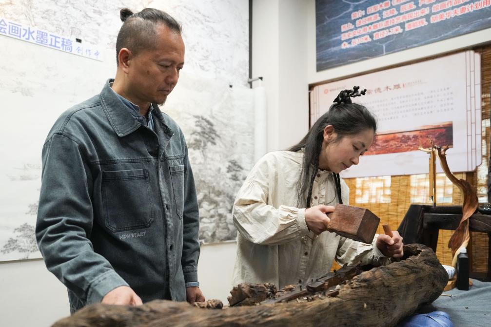 潘能輝和妻子胡美華在湖南常德河街展示木雕。新華社記者 薛宇舸 攝